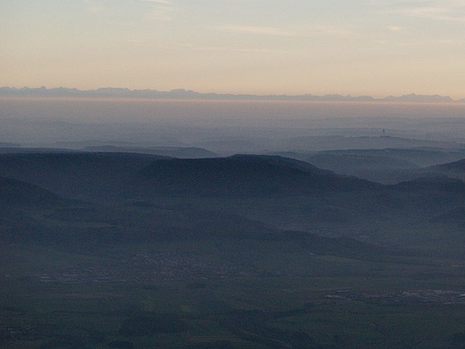 Typische Herbst-Hochdrucklagen-Inversion auf der Schwäbischen Alb. Während die Bodenluft sehr dunstig ist, sind die 200 km entfernten Alpengipfel glasklar sichtbar und scheinen auf der scharf abgegrenzten Inversion zu „schwimmen“ (Blick aus dem Flugzeug, 